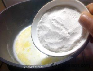 adding rice flour to the water, milk, ghee mix with salt for making rice dough of modak