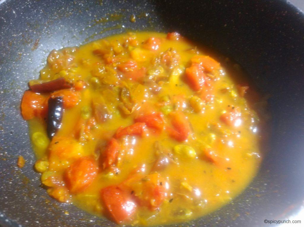 add water to the pan to cook tomato, khejur, aamsotto and kismis perfectly
