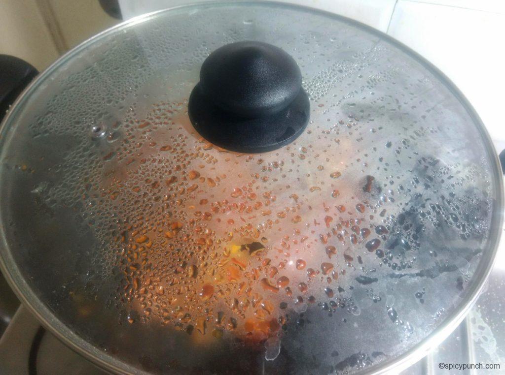 cover the pan with the lid for making the tomato and khejur soft to prepare this bengali tomato khejur chutney